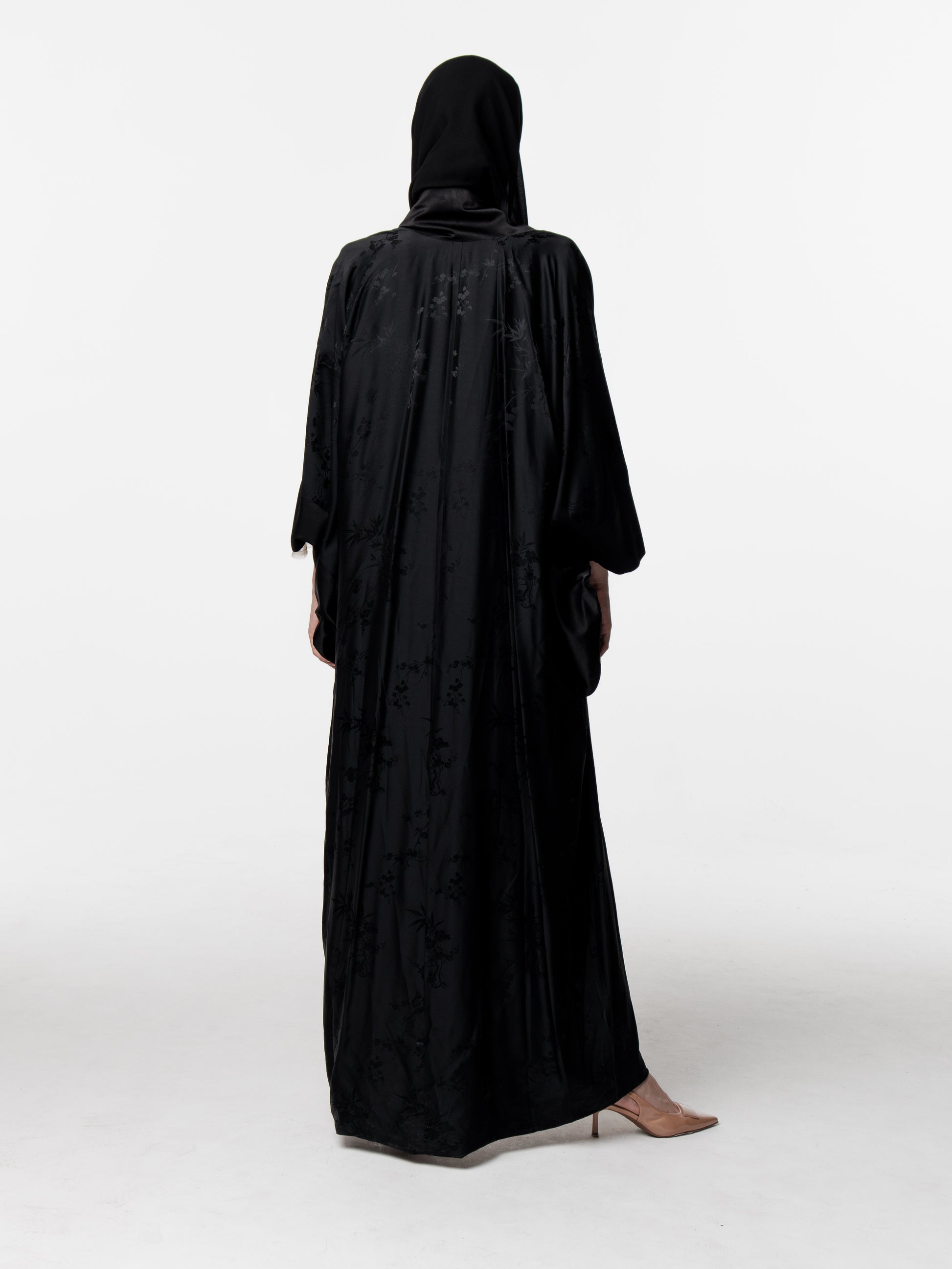 Person wearing a black abaya on a white background